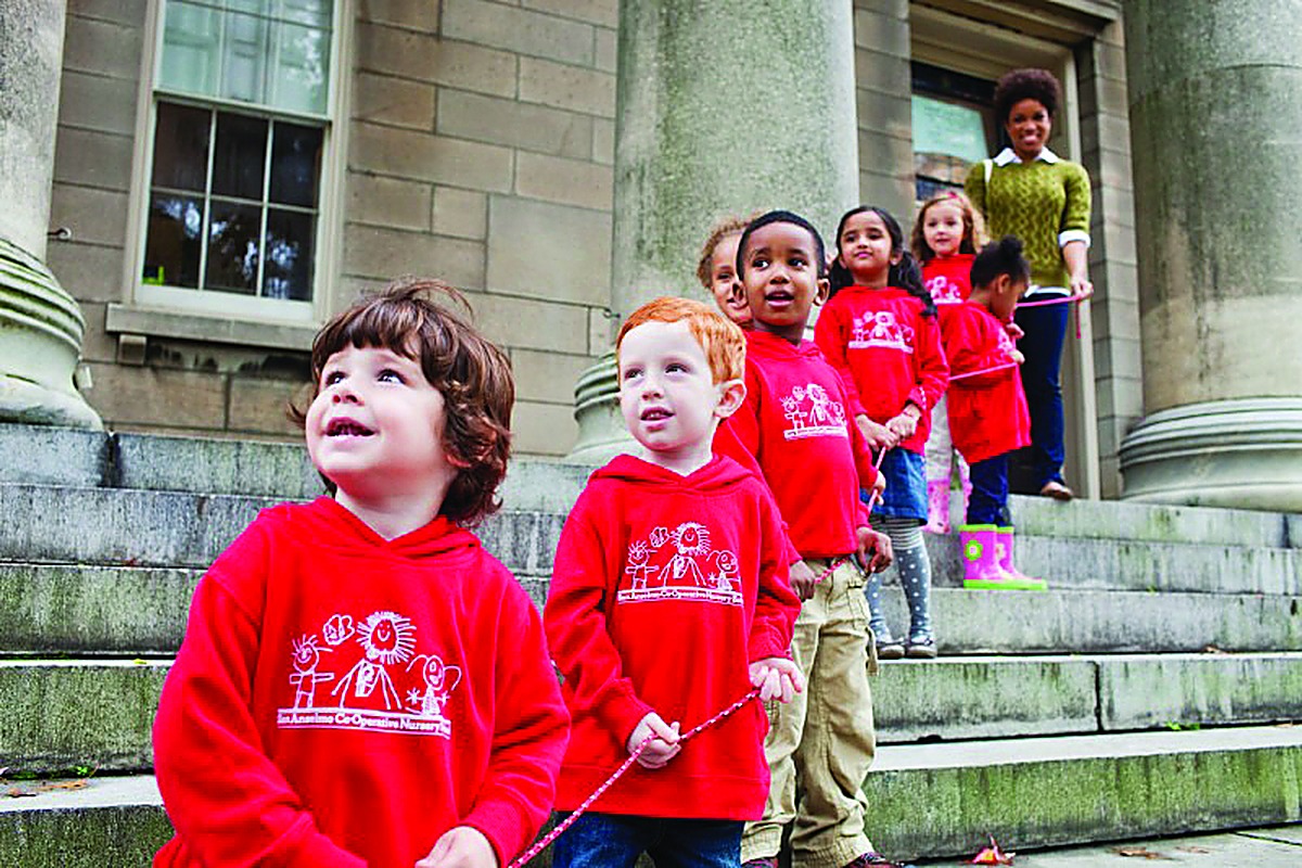 Young children in red HP hoodies on stone steps, the next generation of learners